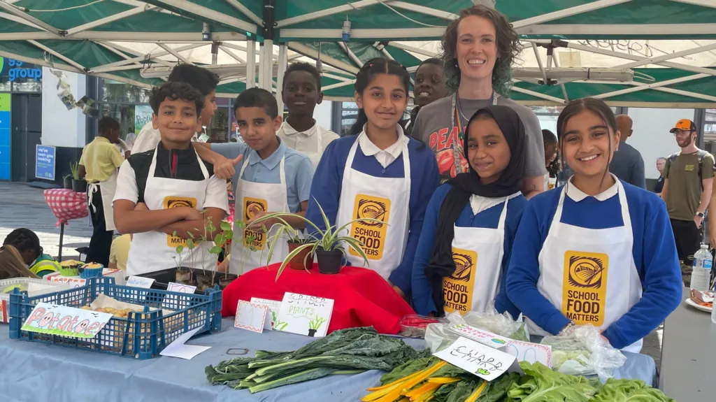 Schoolchildren sell own-grown produce at market